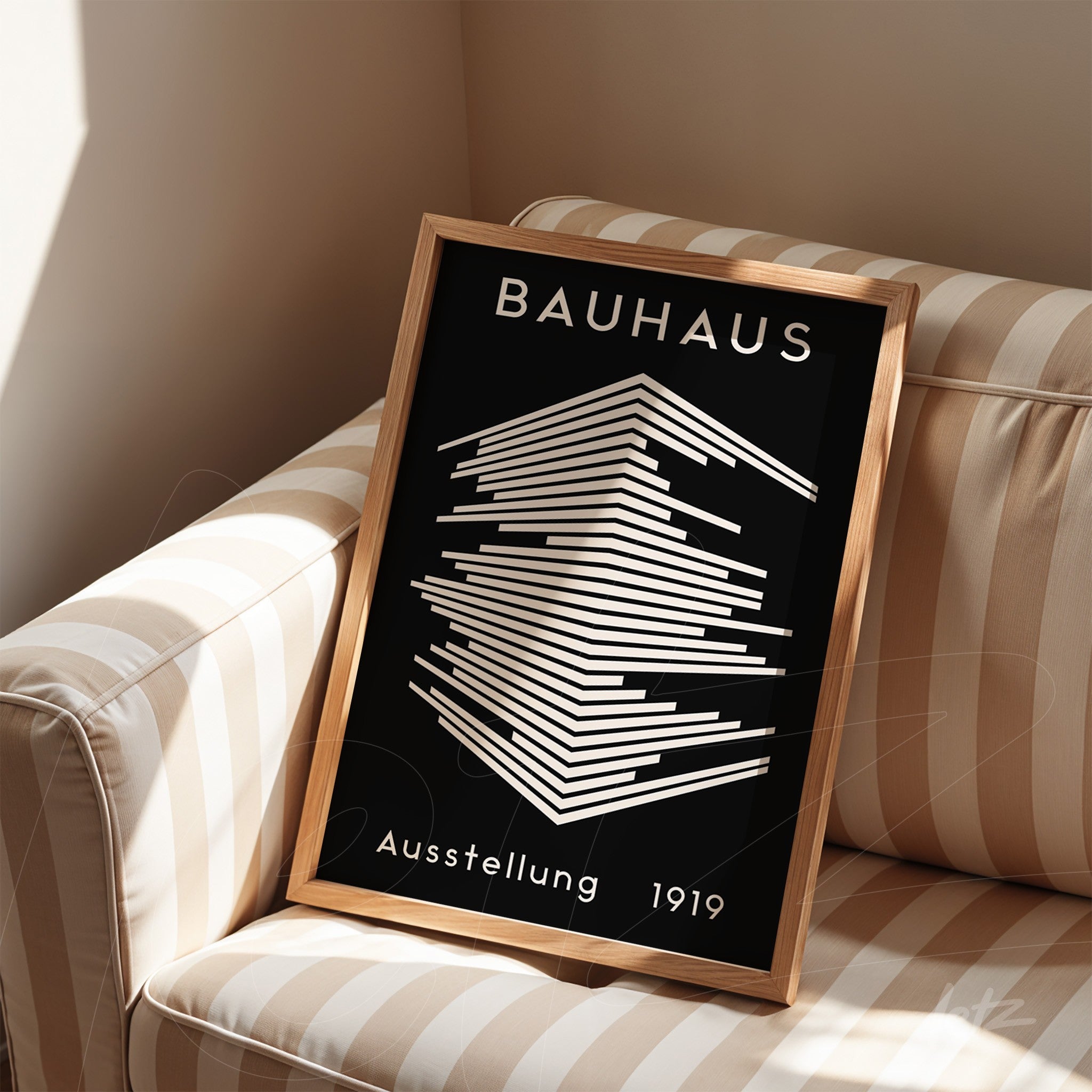minimalist bauhaus art in a light wood frame displayed on a striped sofa