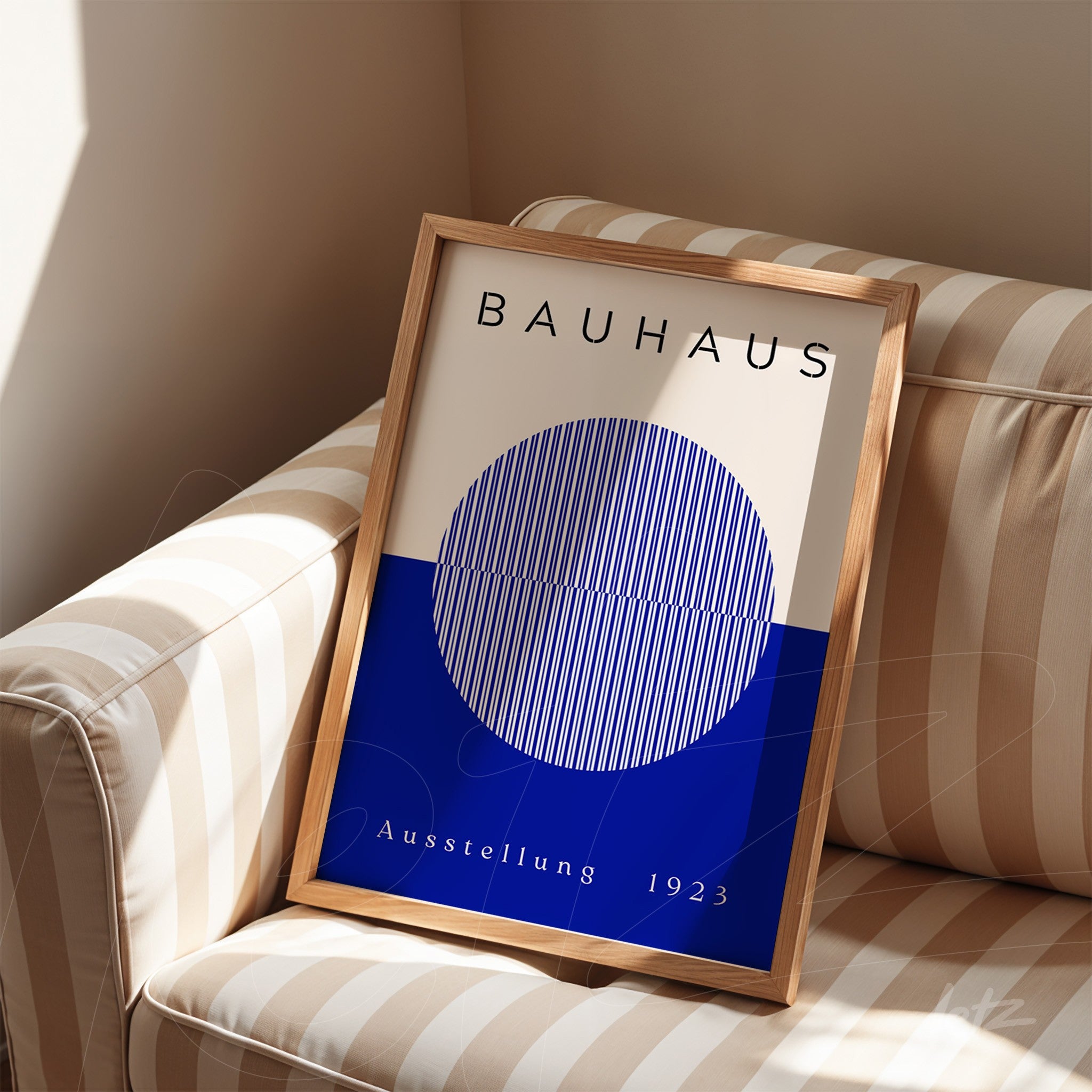bauhaus art print featuring a geometric blue circle in a light wood frame resting on a striped sofa