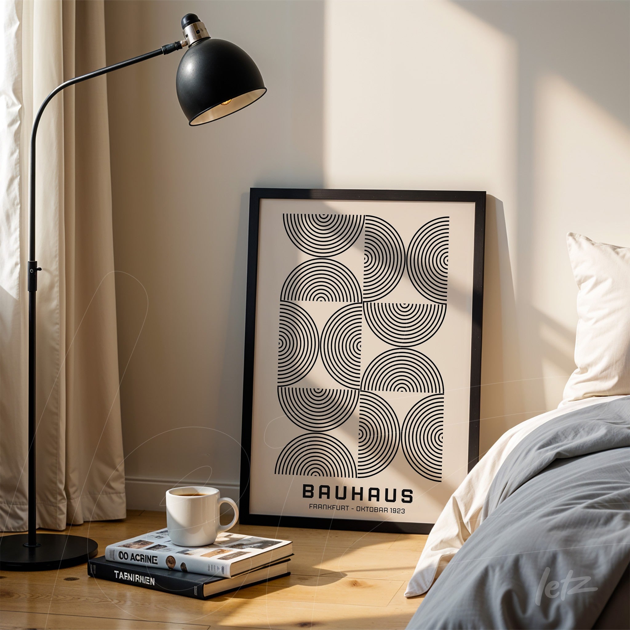 black and white minimalist geometric design poster in black frame, leaning on the floor beside a lamp and a stack of books