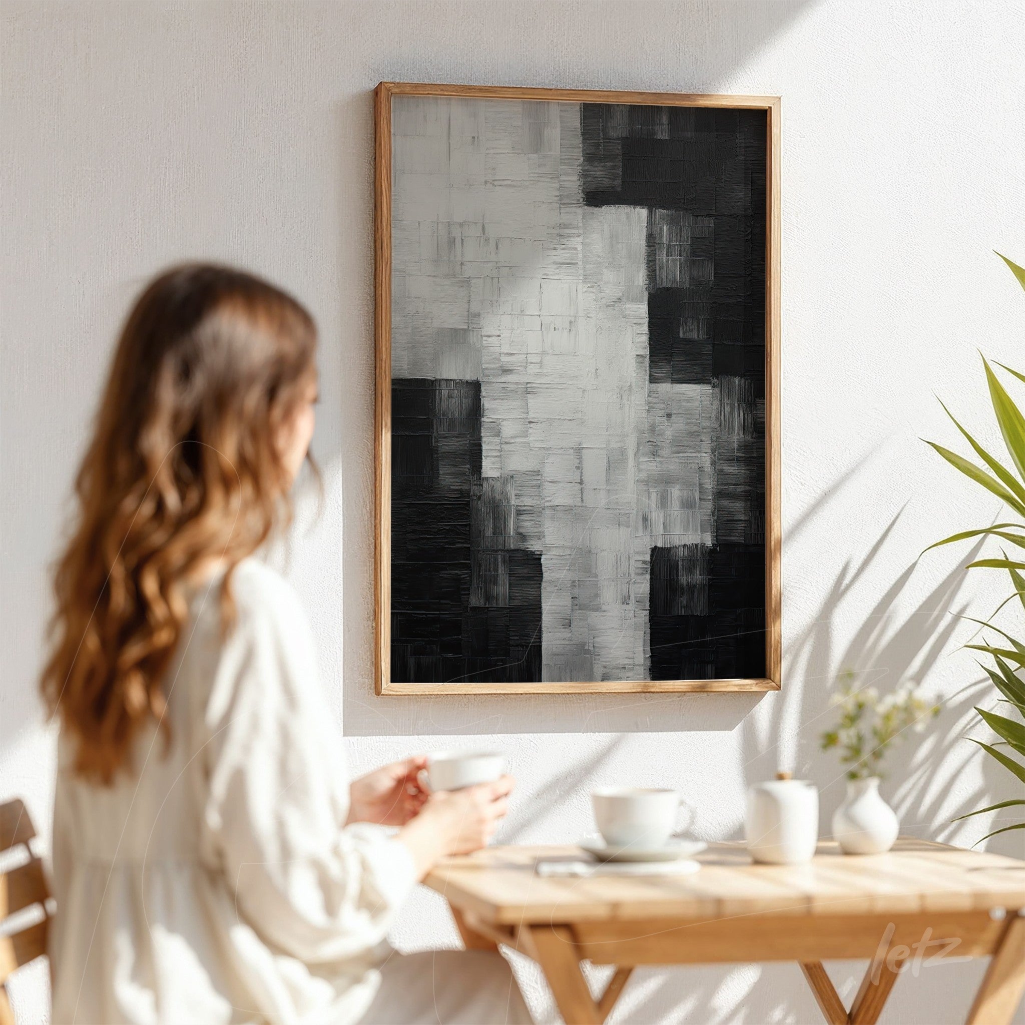 framed abstract wall art in black and white with varied textures displayed on a white wall