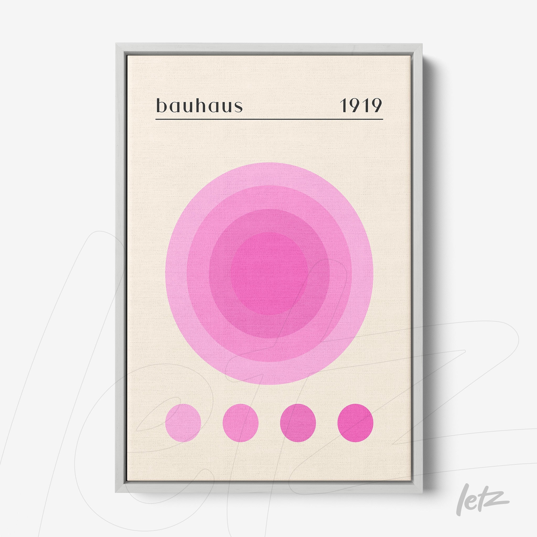 poster print with concentric circles in shades of pink displayed in gray frame against a light wall
