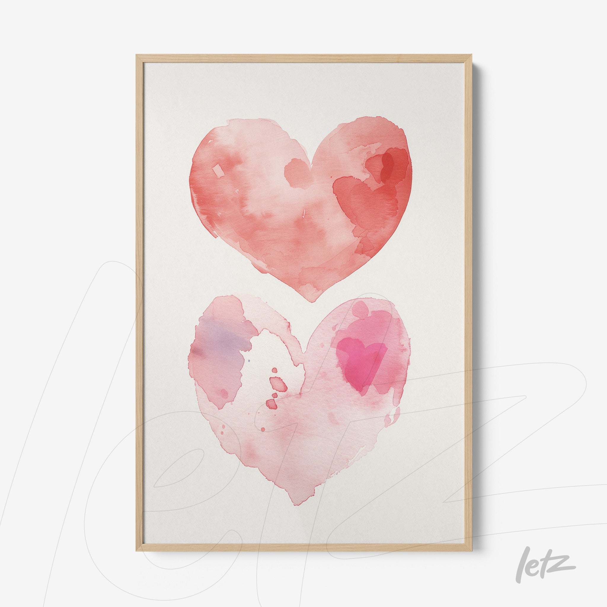 framed wall art featuring two watercolor hearts in shades of pink and red with a light wood frame