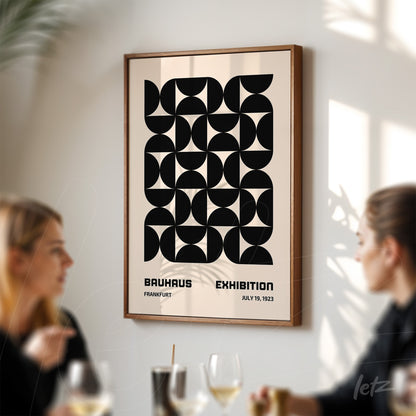 framed vintage geometric art of 1923 Bauhaus exhibition in dark wood frame displayed on light-colored wall