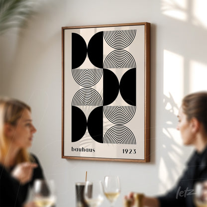 geometric black and white bauhaus style art print from 1923 in wooden frame displayed in a modern café setting