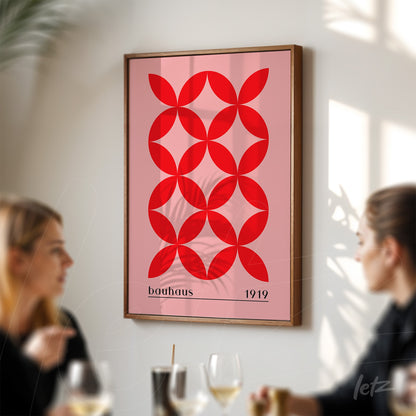 framed wall art featuring red geometric bauhaus style design in dark wood frame displayed on white wall