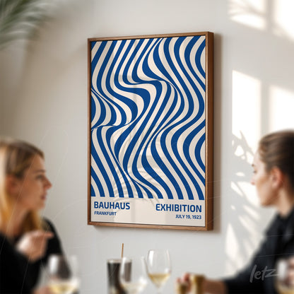 poster with blue and white wavy pattern in dark frame, displayed on white wall