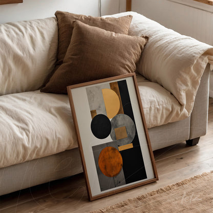 framed abstract wall art in natural wood showcasing geometric shapes in orange, black, and gray, leaning against a light sofa with brown pillows