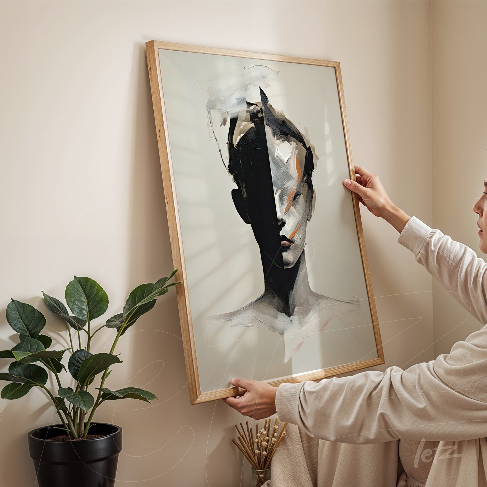 framed wall art in light wood showcasing an abstract portrait of a woman in black and white held vertically