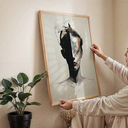 framed wall art in light wood showcasing an abstract portrait of a woman in black and white held vertically