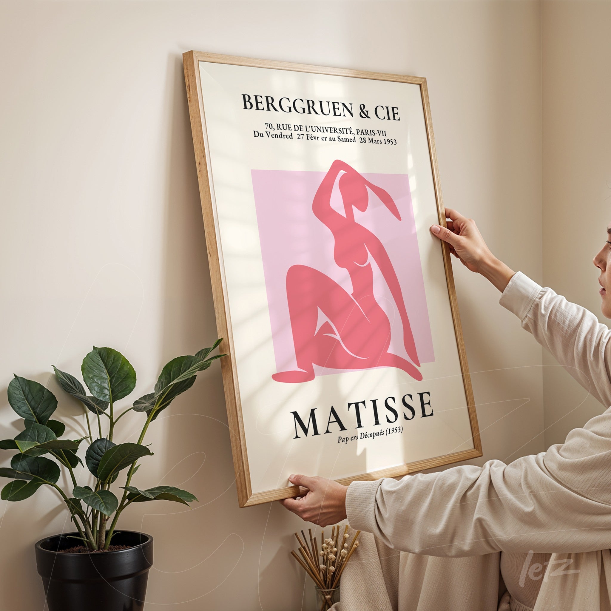 framed contemporary art of a feminine figure in pink tones with light wooden frame
