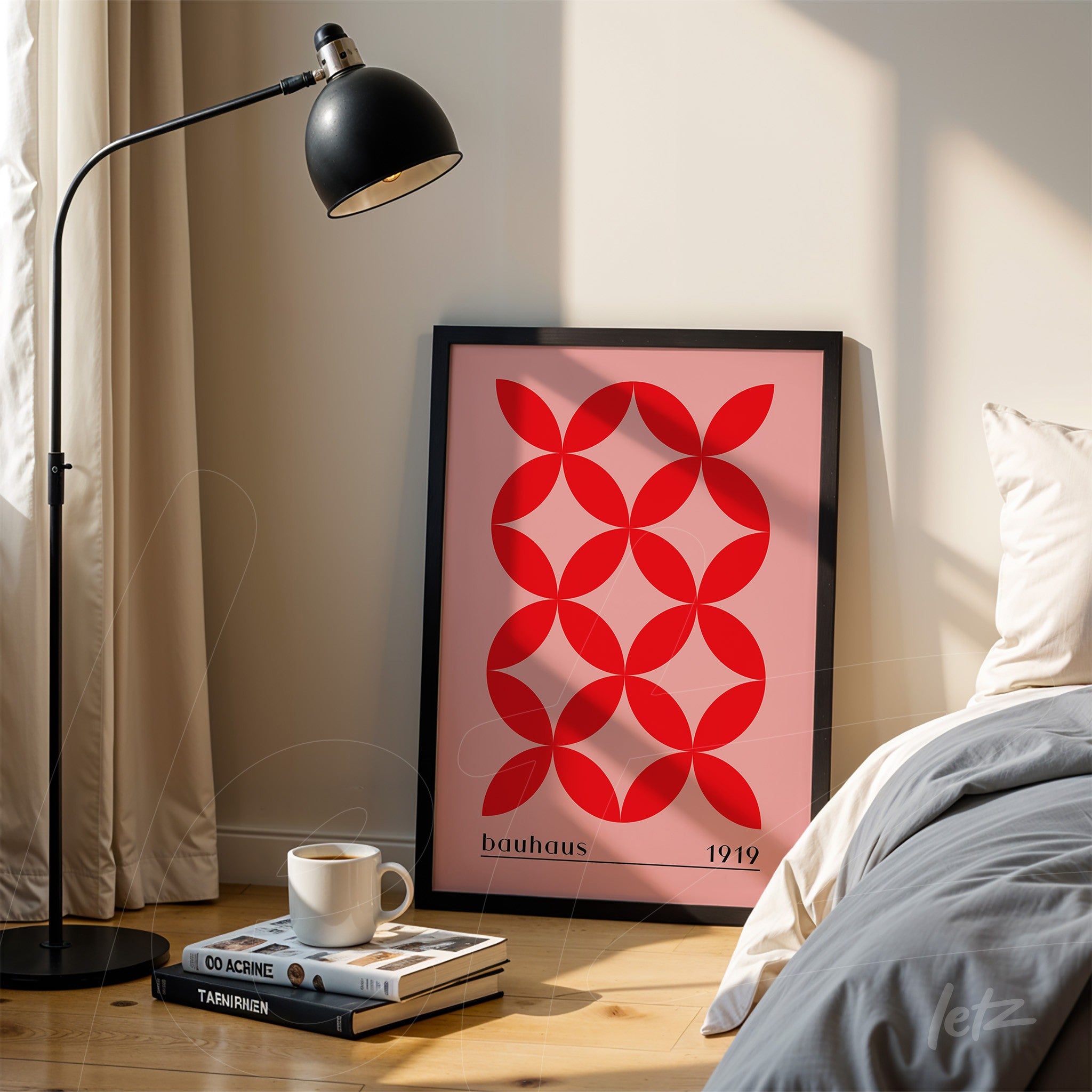 bauhaus style geometric art in red and pink with black frame leaning against a light-colored wall