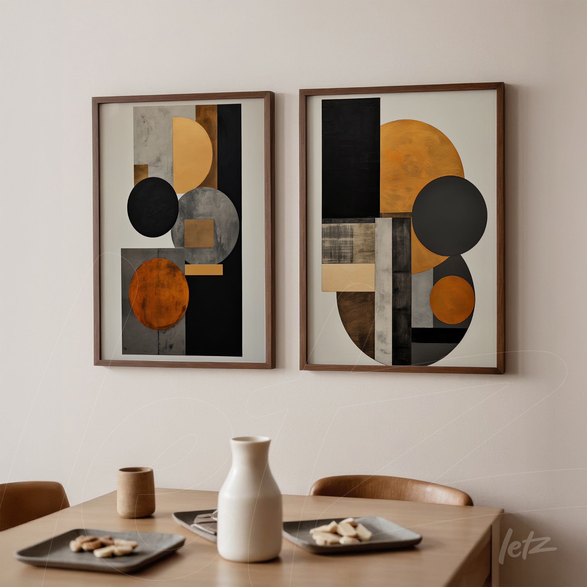 composition of two framed abstract artworks in black, gray, and orange tones with light wood frames displayed on a neutral wall