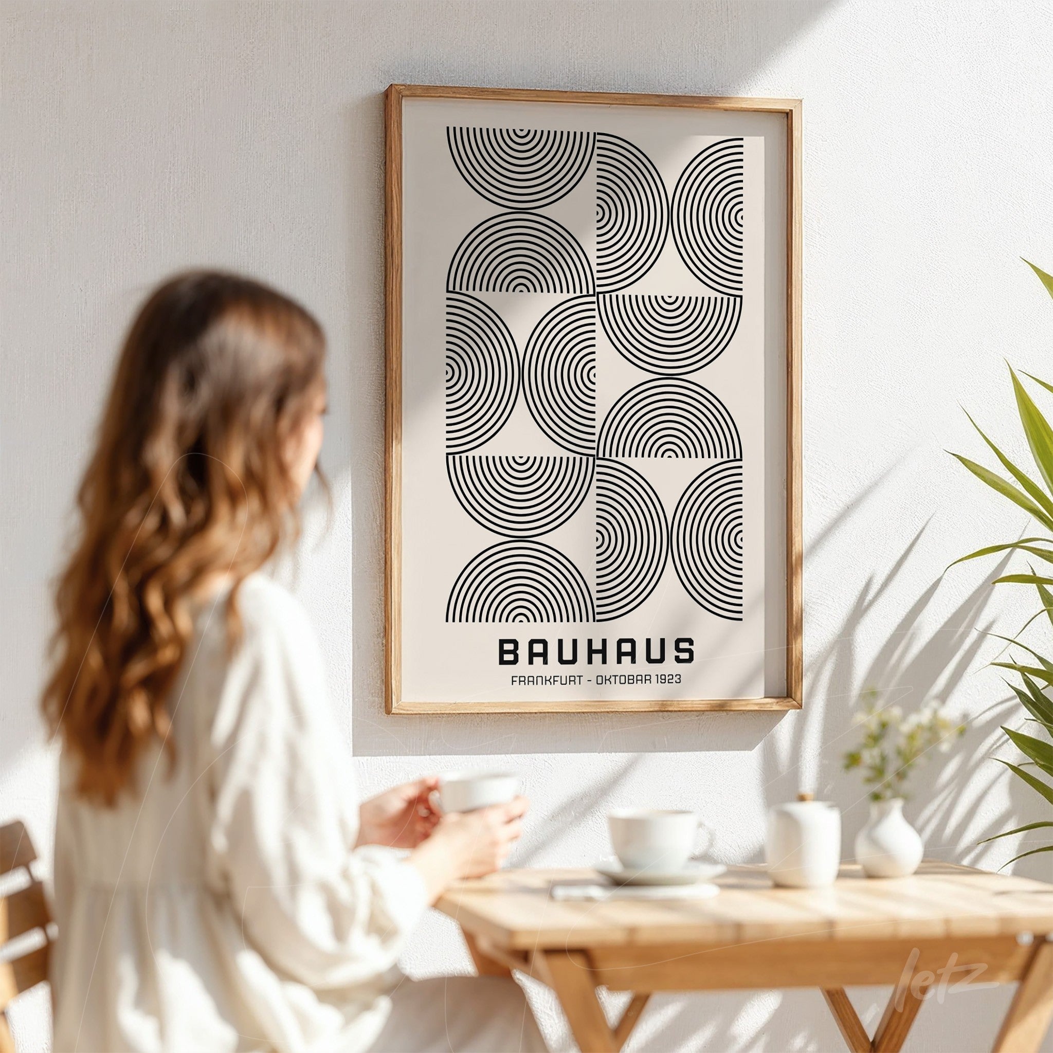 bauhaus geometric art poster print in a light wood frame against a white wall