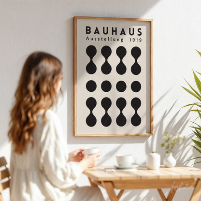 poster featuring geometric bauhaus style design in light wood frame, displayed on a white wall