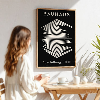 poster featuring geometric Bauhaus-inspired design from 1919 in a light wood frame displayed on a white wall