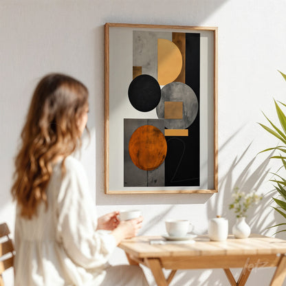decorative wall art with geometric shapes in black, orange, and gray in a light wood frame displayed on a white wall with soft shadows