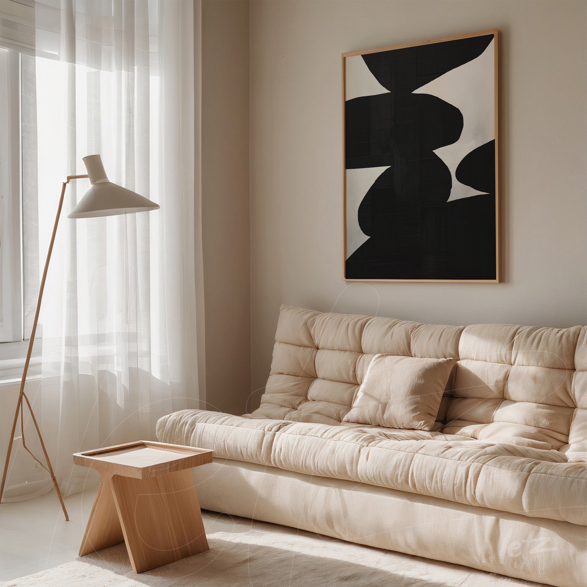 modern black and white abstract art framed in a light wood frame, displayed in a minimalist setting with a beige sofa