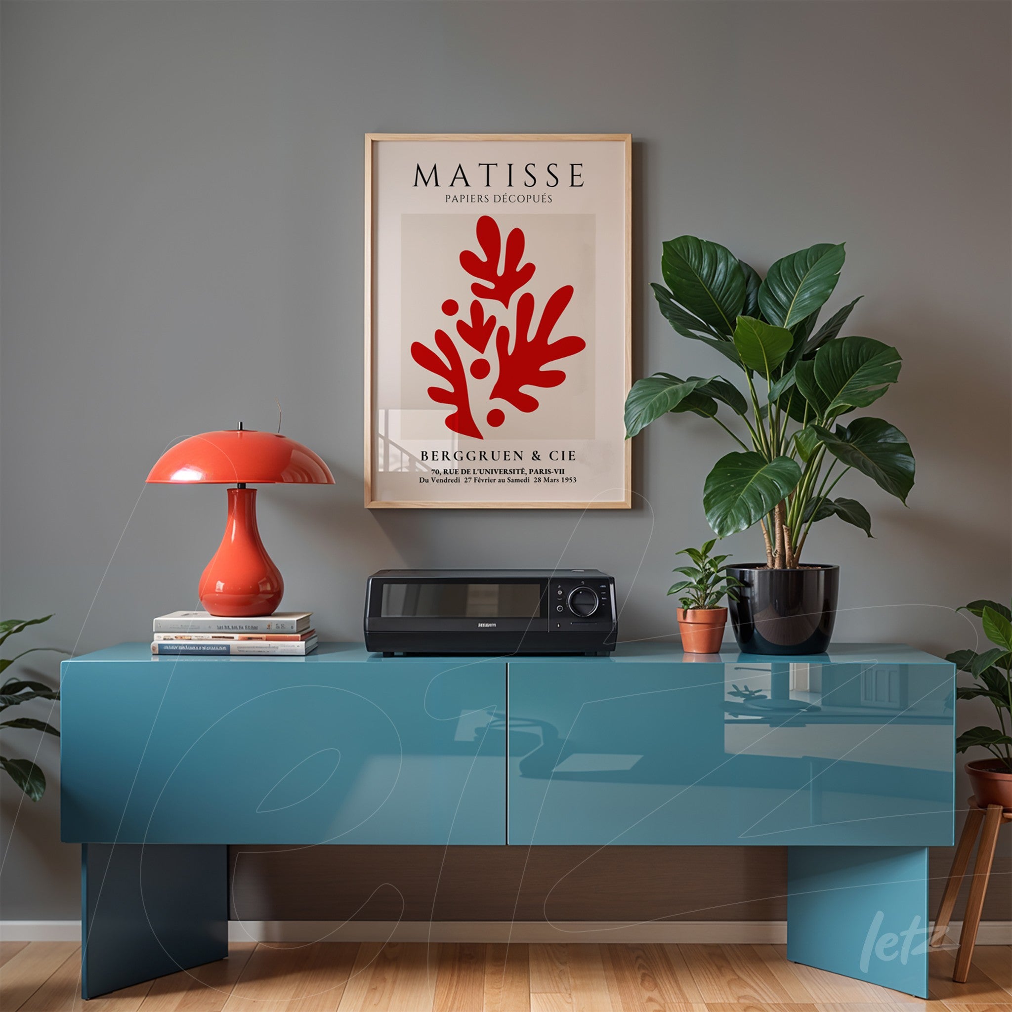 framed modern artwork featuring red coral designs on gray wall next to a blue cabinet