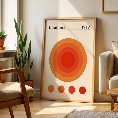 poster print featuring concentric circles in orange shades with a light wooden frame, displayed in a sunlit room