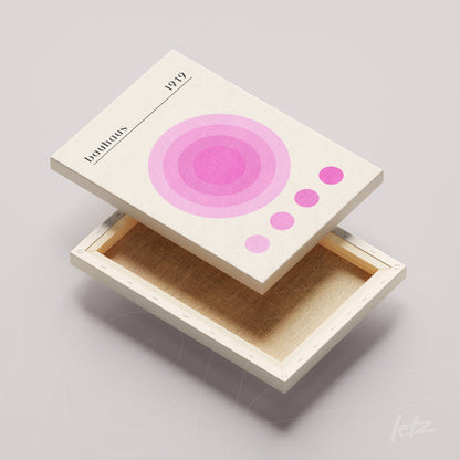 canvas print featuring a minimalist design of pink and lilac circles on a light background, paired with a light wood frame