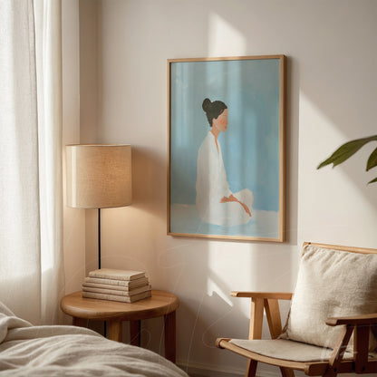 framed minimalist art of a seated woman in blue background with light wooden frame