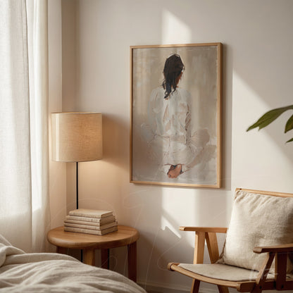framed abstract artwork of a seated figure seen from behind in light wooden frame displayed in softly lit room