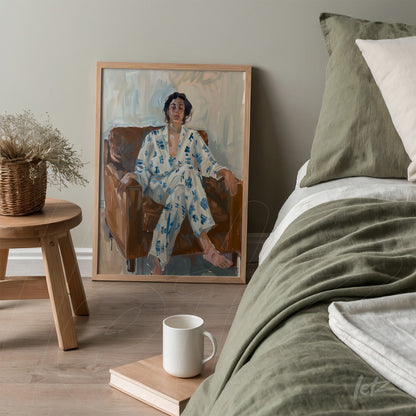 framed portrait of a woman sitting on a brown sofa, displayed in a cozy setting with light wooden frame