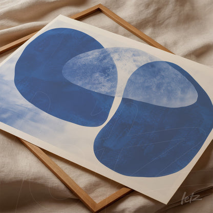 abstract wall art in shades of blue displayed in a light wood frame
