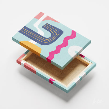 ```json
{
  "alt": "canvas com arte abstrata em tons de rosa, azul e amarelo com formas curvas em fundo claro",
  "alt_en": "canvas featuring abstract art in shades of pink, blue, and yellow with curved shapes on a light background"
}
```