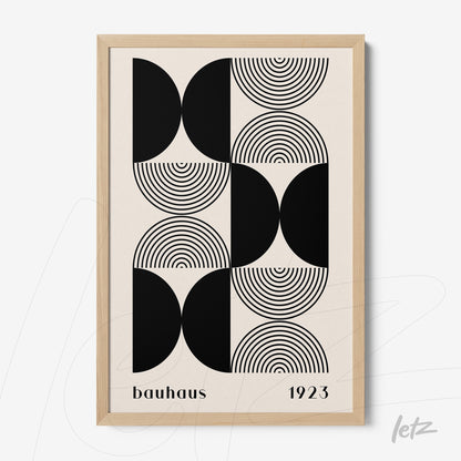 poster print of Bauhaus art with black geometric shapes and concentric circles in light wood frame