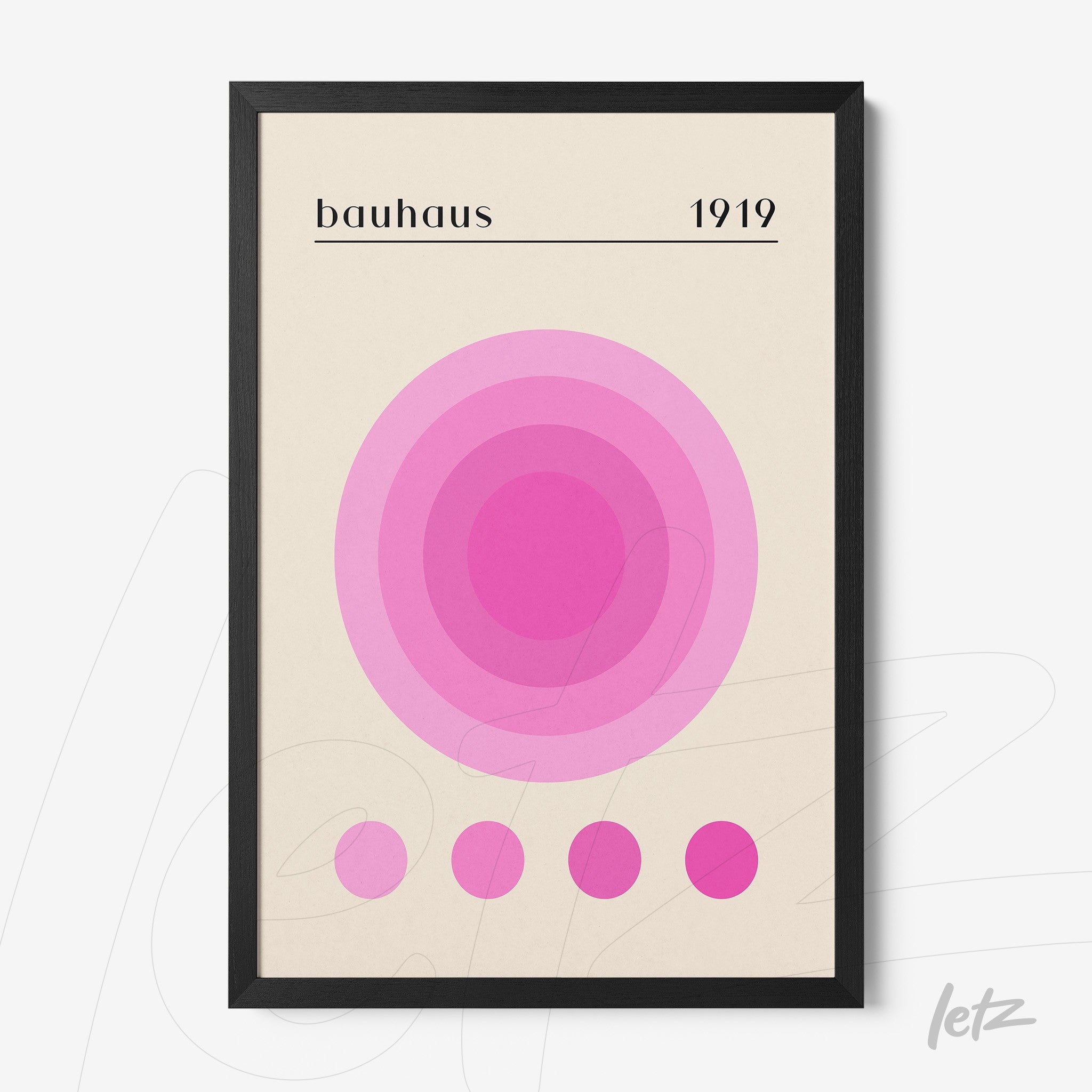 poster print featuring geometric art with concentric circles in shades of pink and text 'bauhaus 1919', framed in a minimalist black frame