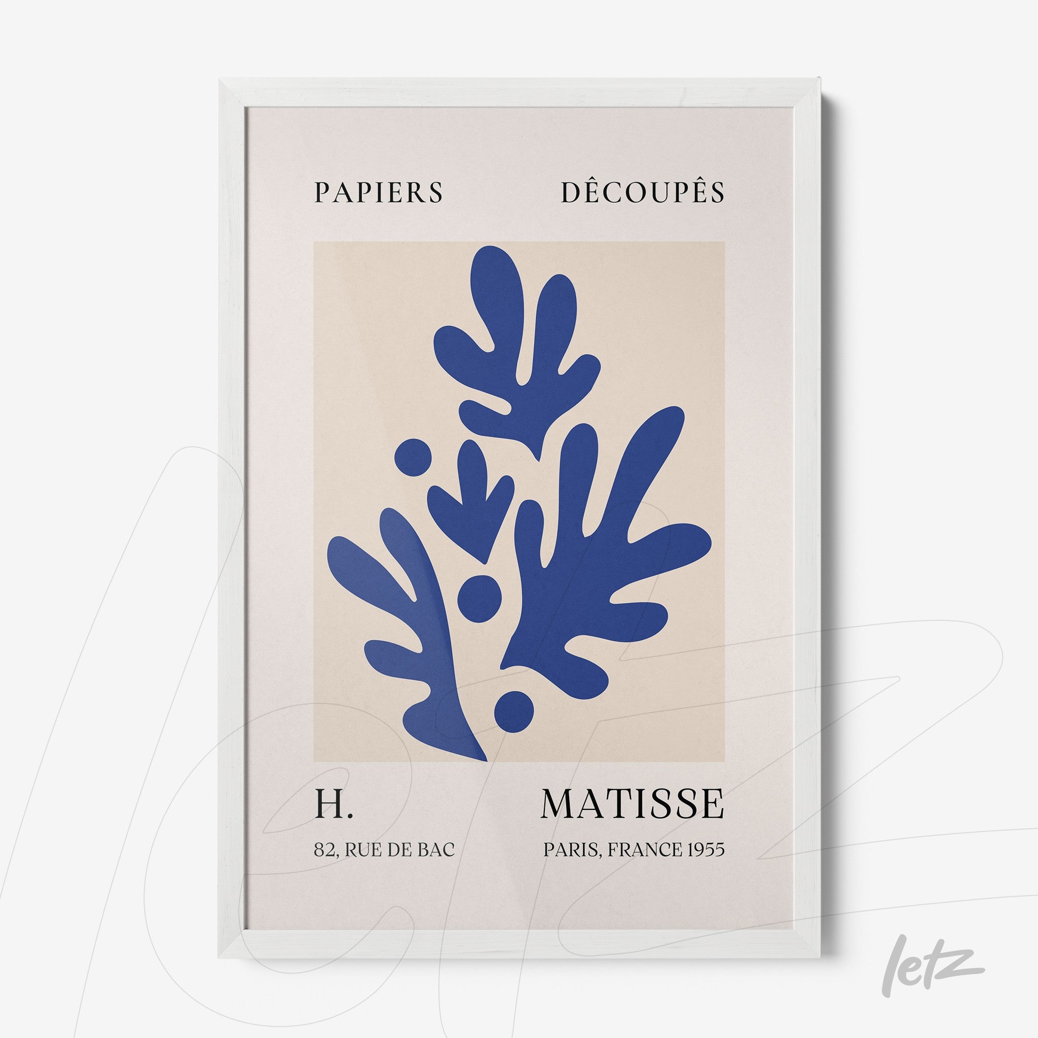 framed wall art featuring cut-out paper design on light background with white frame, showcasing abstract blue shapes