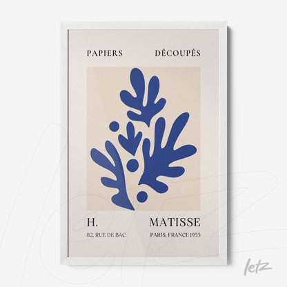 framed wall art featuring cut-out paper design on light background with white frame, showcasing abstract blue shapes