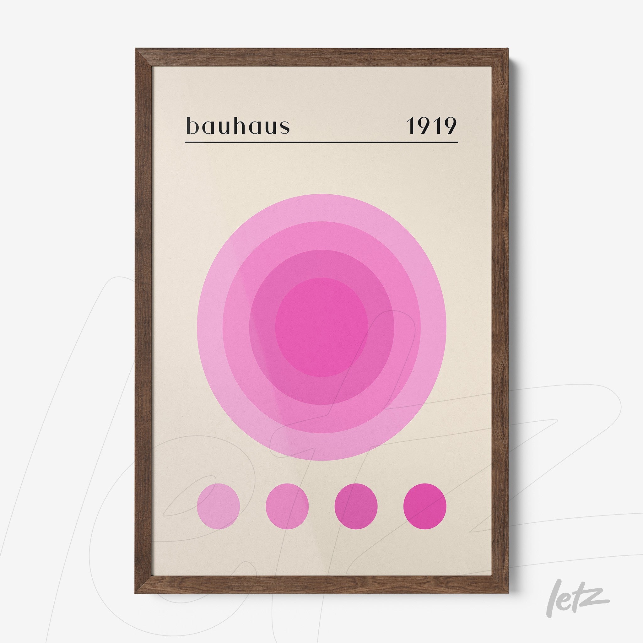 poster print featuring concentric circles in shades of pink on a light background framed in dark wood