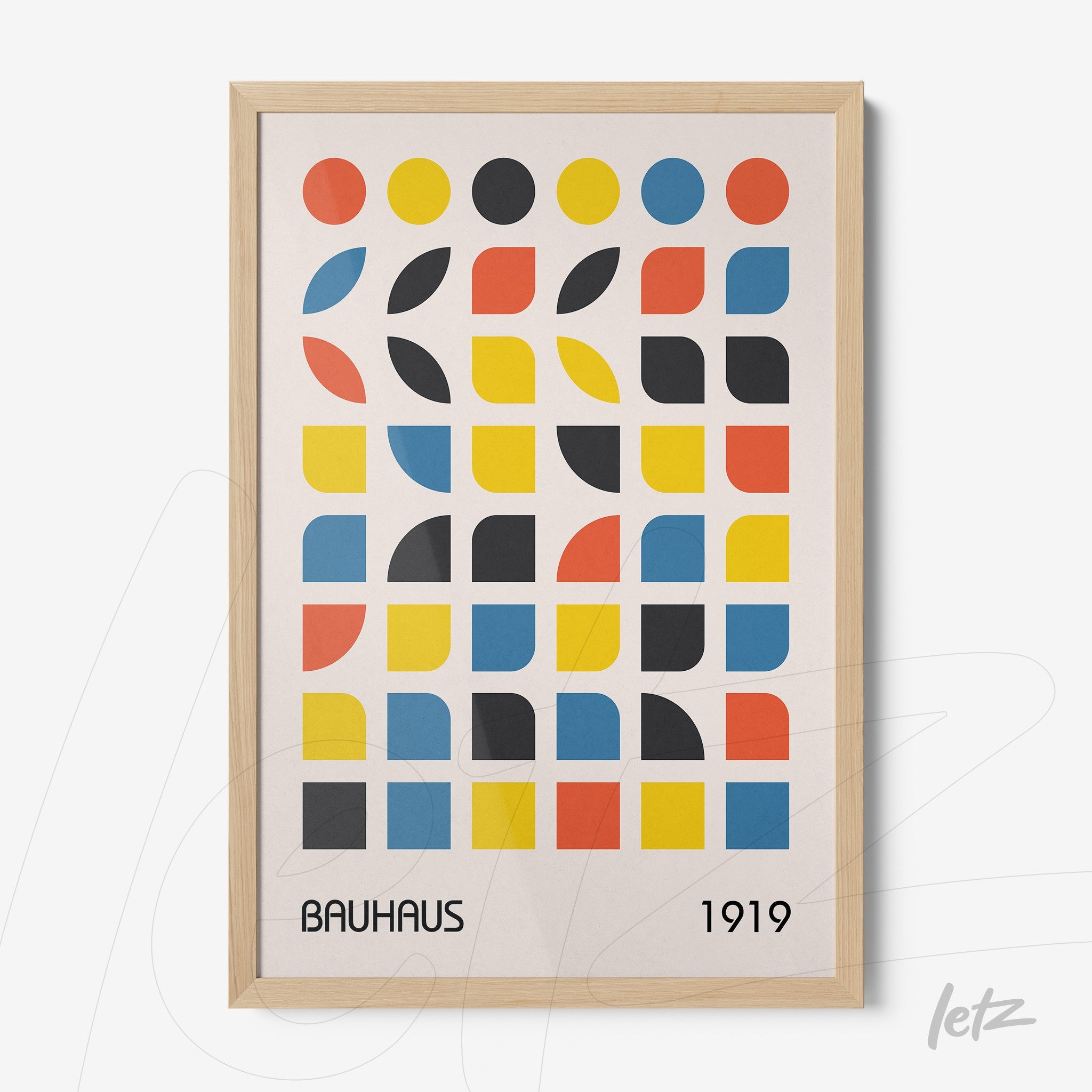 framed wall art with colorful geometric bauhaus style pattern in light wood frame