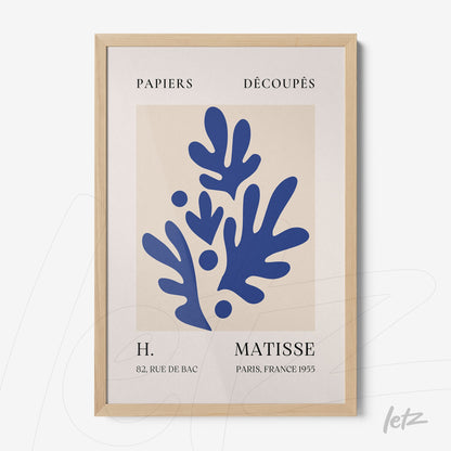 framed wall art featuring abstract blue organic shapes on light background with light wood frame