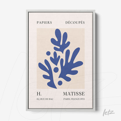 framed wall art featuring abstract blue leaves on a light background with silver frame