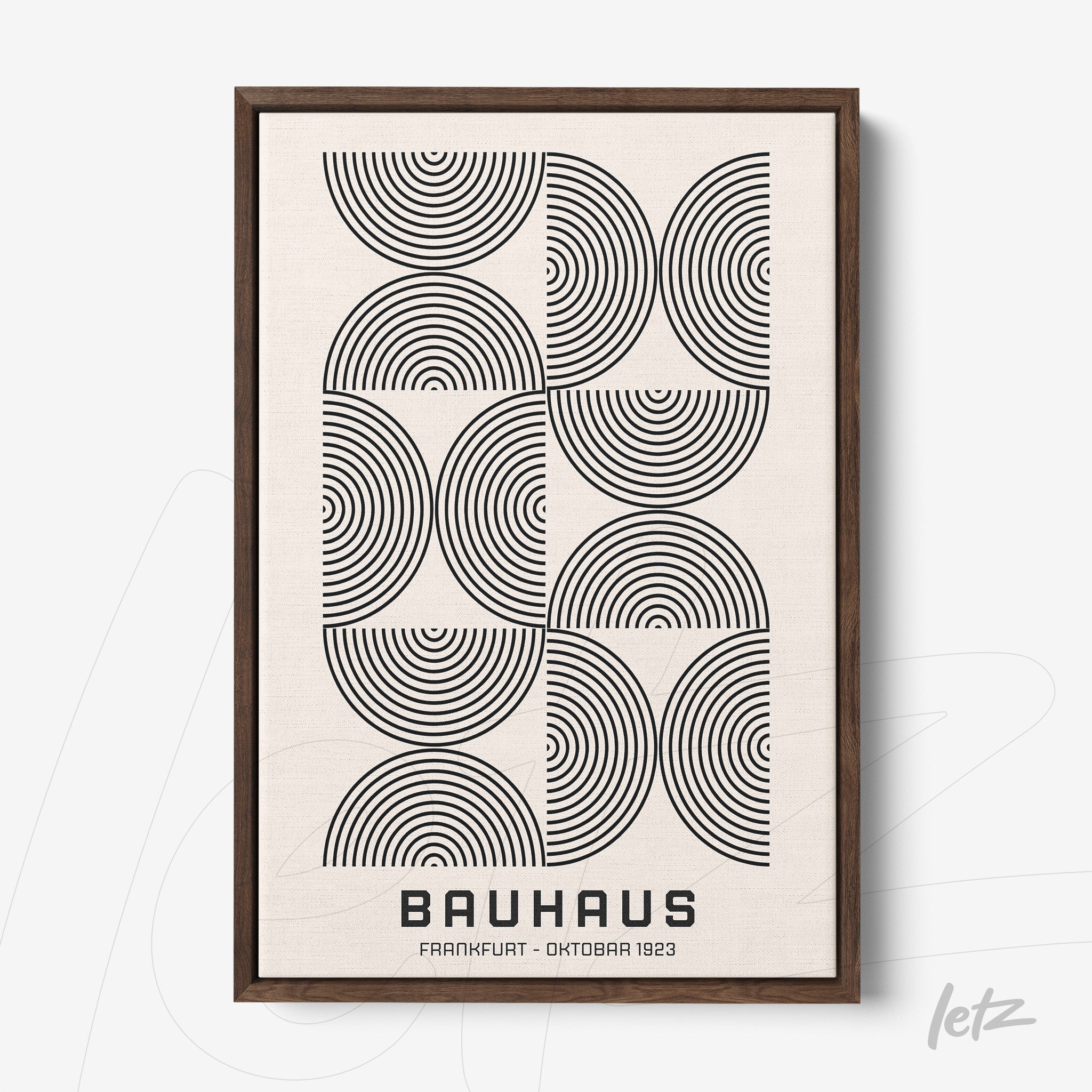 framed wall art featuring black concentric circles on a white background with a dark wood frame