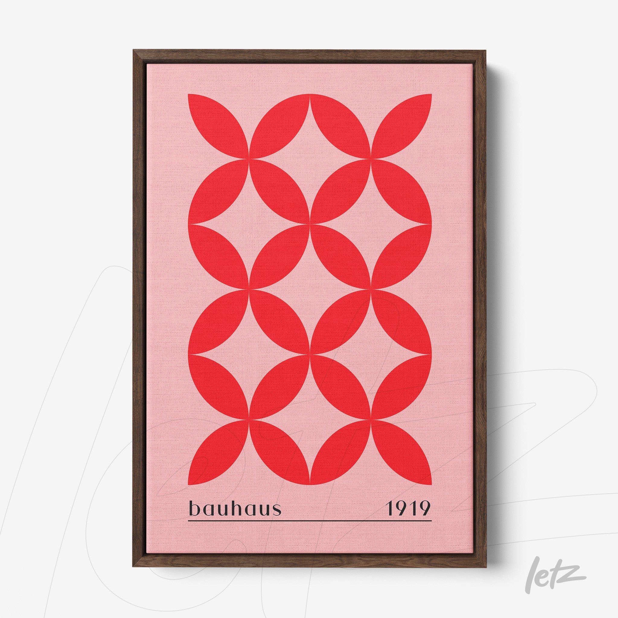 framed artwork with red geometric pattern on pink background, text bauhaus 1919, dark wood frame