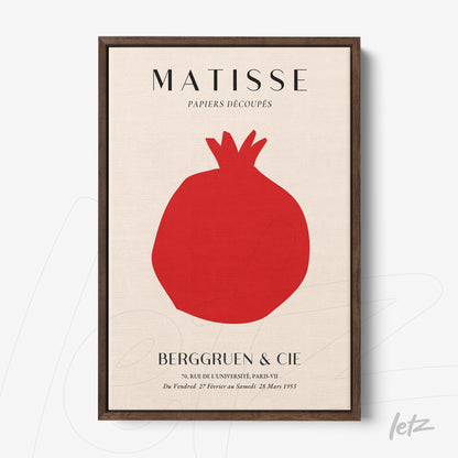 modern art print of red pomegranate on light background, dark wooden frame