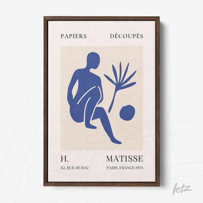framed wall art featuring simplified blue shapes on beige background, dark wood frame