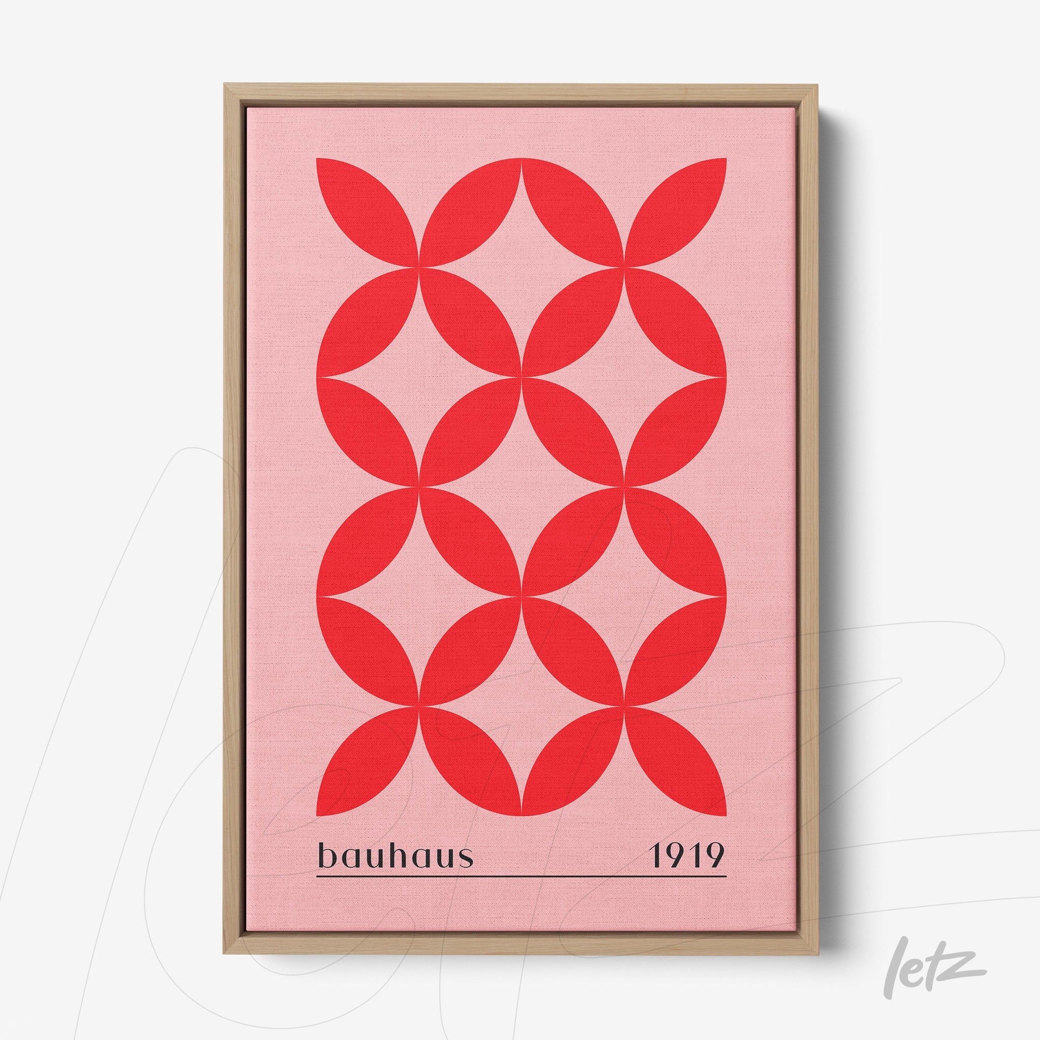 poster print with red geometric design on a pink background, light wood frame