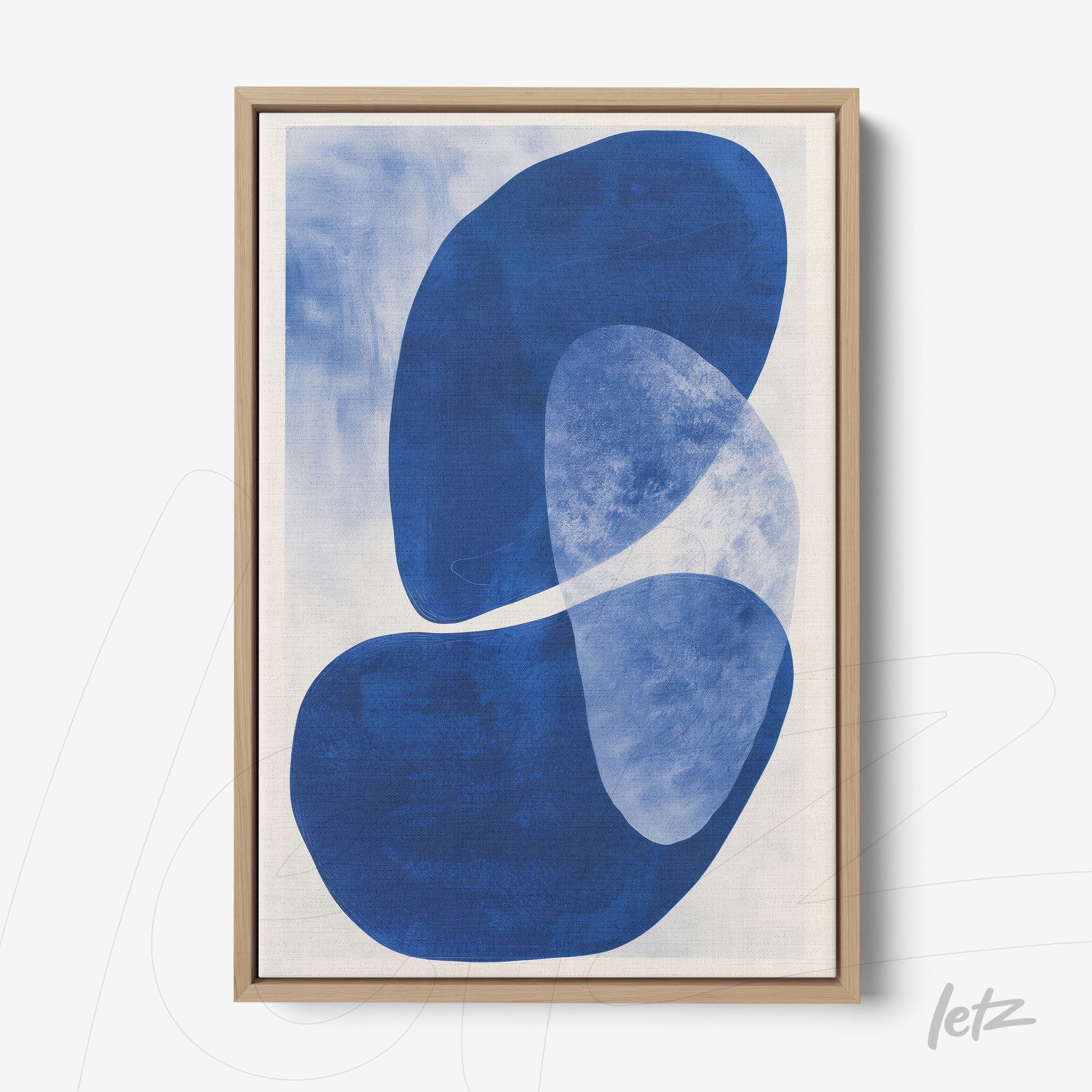 abstract art print in shades of blue with oval shapes on a light background, framed in a light wood