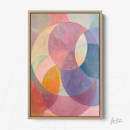 abstract wall art featuring circular shapes in pastel colors, framed in light wood