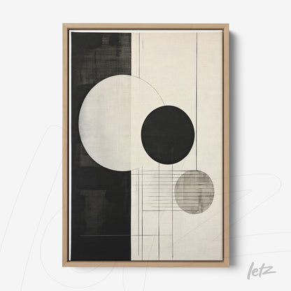 abstract wall art featuring circular shapes in black and white, framed in light wooden frame