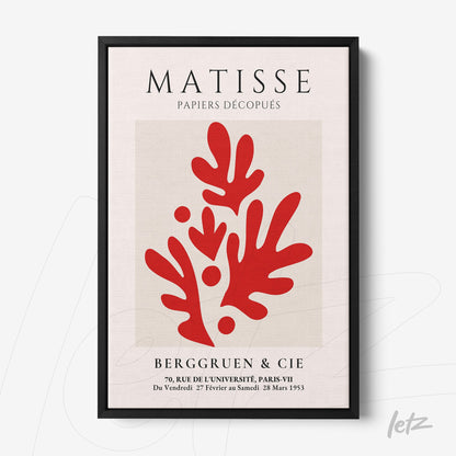 framed wall art featuring abstract red leaves on a light background with a black frame