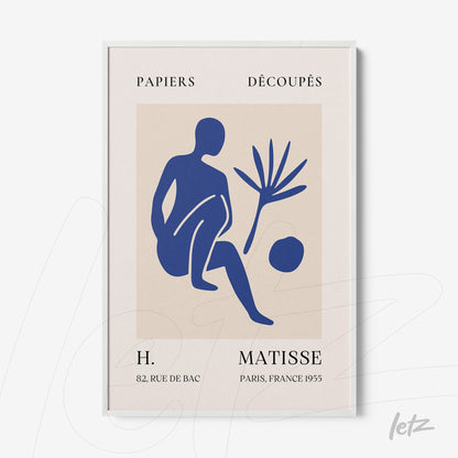 framed modern artwork in blue tones depicting a seated figure and plant with a white frame