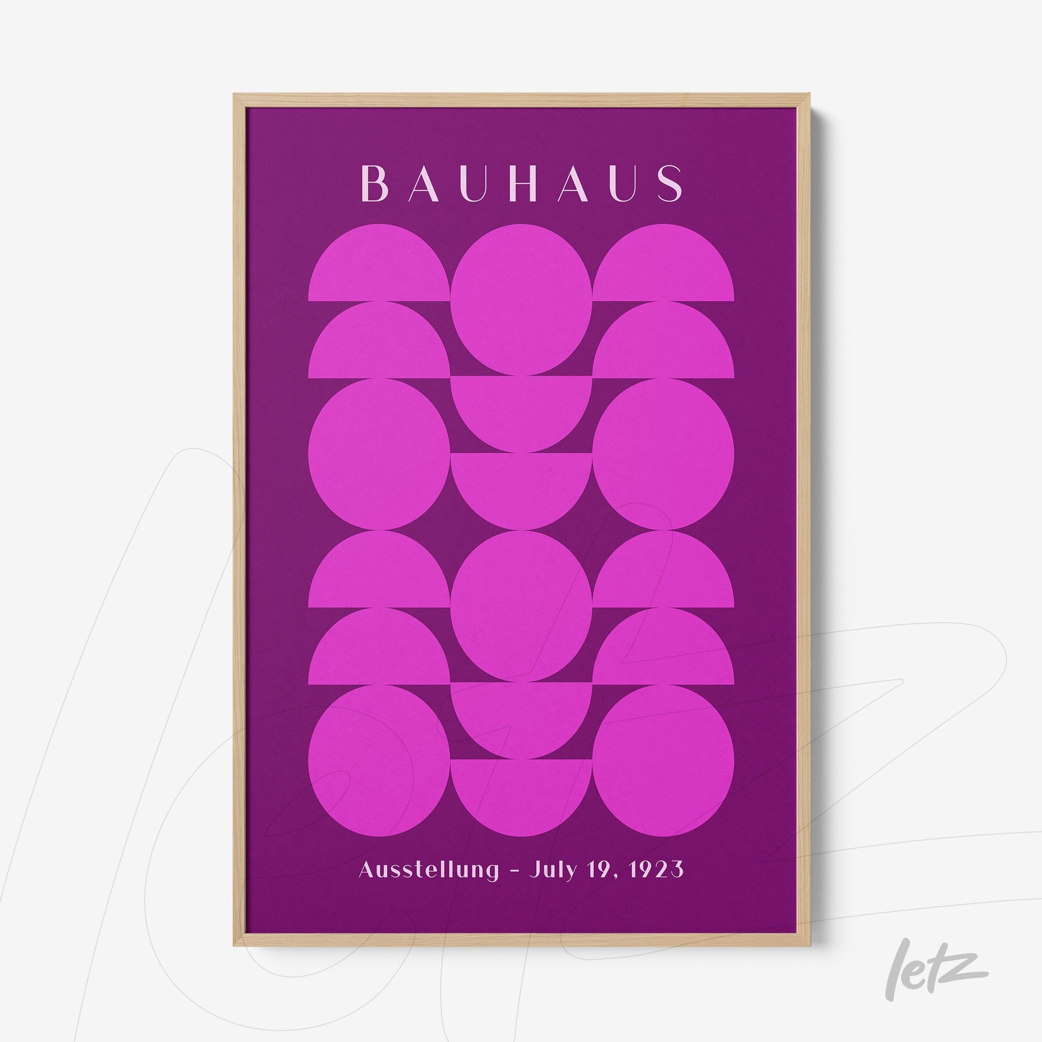 poster print of geometric art with circular pink shapes on a purple background, framed in light wood