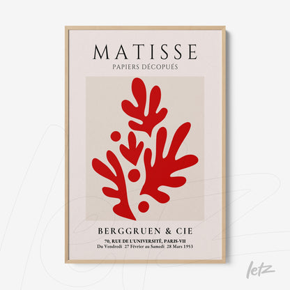 framed modern art print in shades of red depicting organic shapes on a neutral background with light wood frame