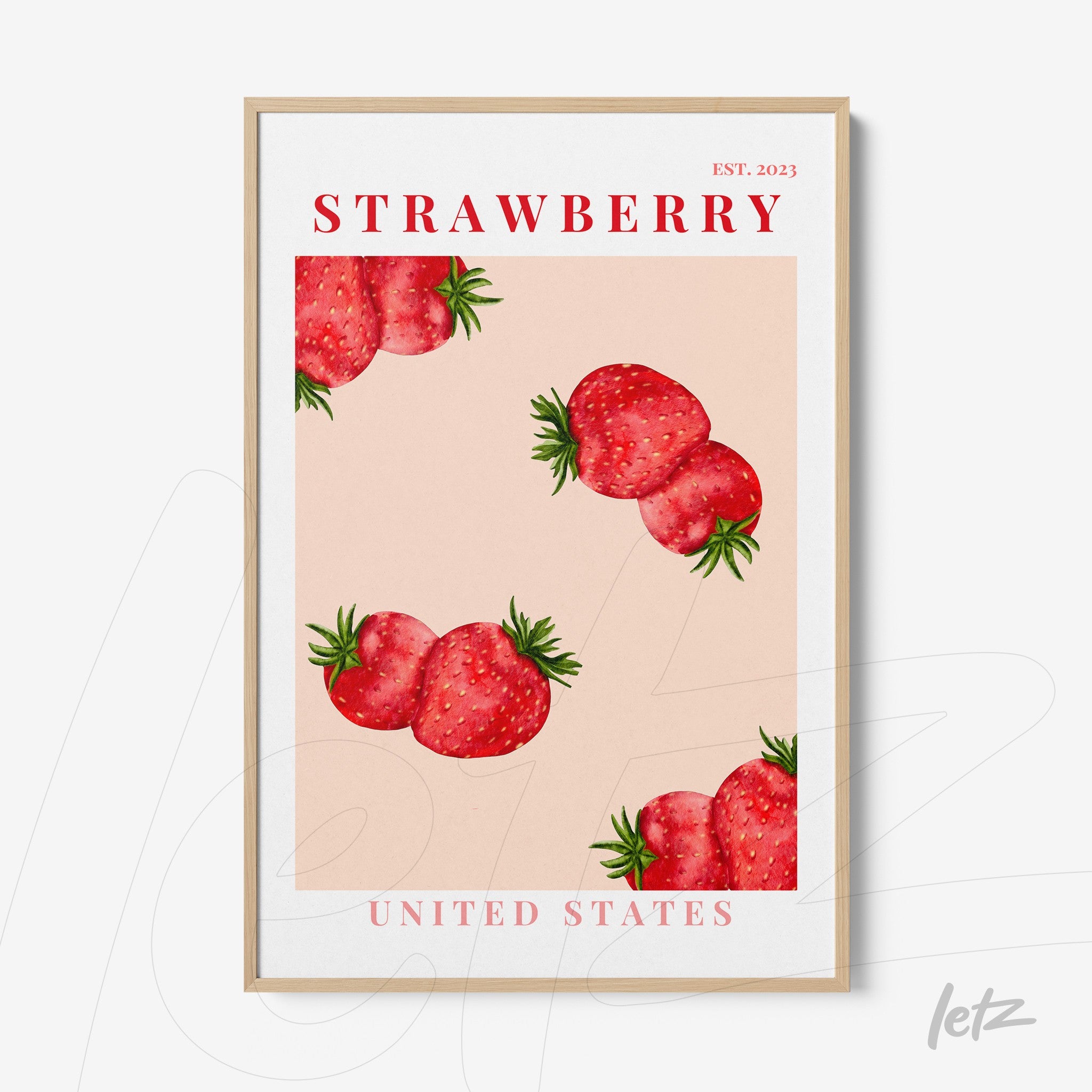 framed wall art featuring strawberries on a pink background with a light wooden frame